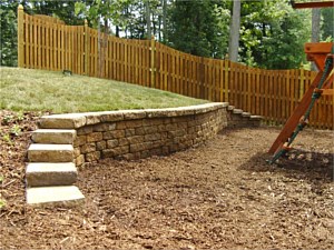 Retaining wall built into a hill to create a playground area from a previously unusable space